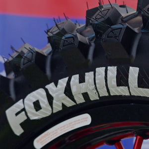 Extreme close up of the FOXHILLS logo on the sidewall of a Plews Tyres motocross tire.