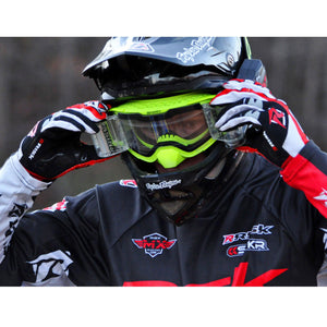 male motocross racer wearing black helmet, Risk Racing V3 goggles, and using hands his to adjust the Ripper Auto Roll-Off system