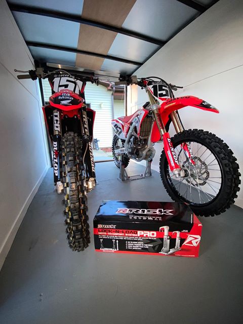 Two dirt bikes loaded inside a toy hauler using two risk racing lock-n-load pro strapless moto transport units.