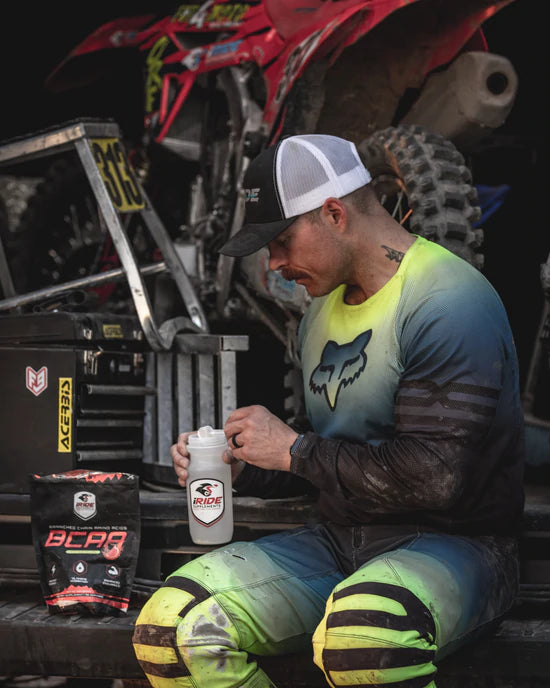 Motocross rider adding iRidee Supplements BCAA's to their water bottle before a training session to improve their hydration & endurance.