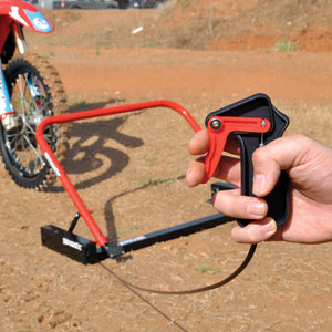 Holeshot Starting Gate Manual Version out on the track with a rider lined up to the a gate and a hand holding the trigger mechanism