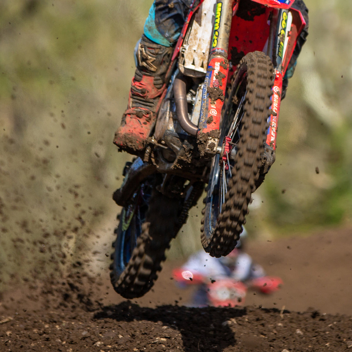 Motocross racer leaving a jump towards camera. Super zoomed in on just the tires. Plews Tyres brought to you by Risk Racing.