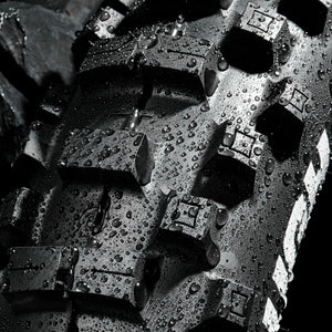 Super close up of a wet brand new Plews Tyre in a black studio environment. Detail shot of the treads.