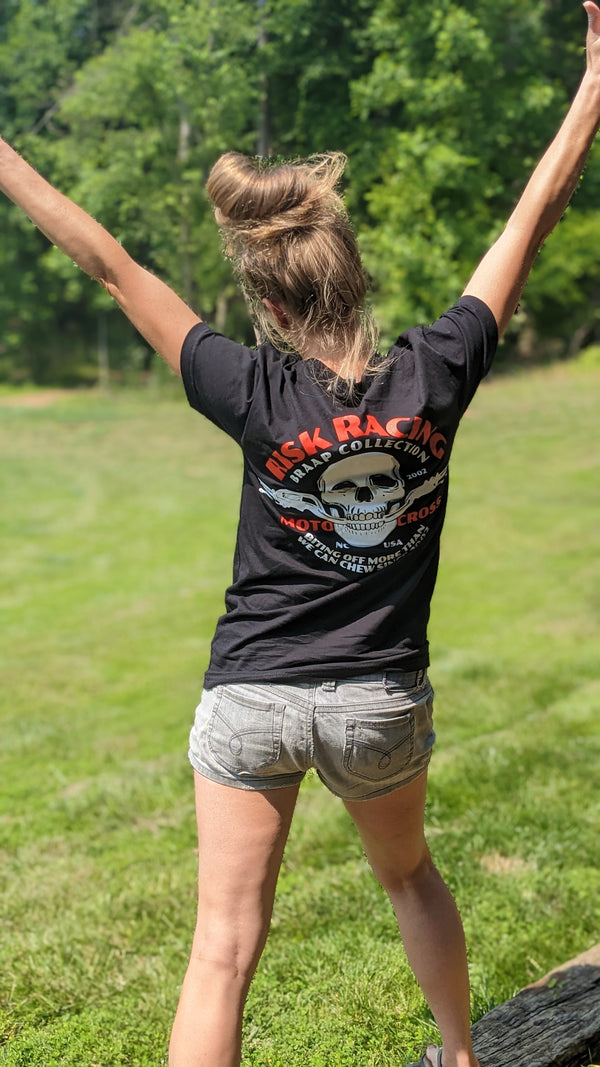 female with back to camera wearing a black 'bones & bars' t-shirt