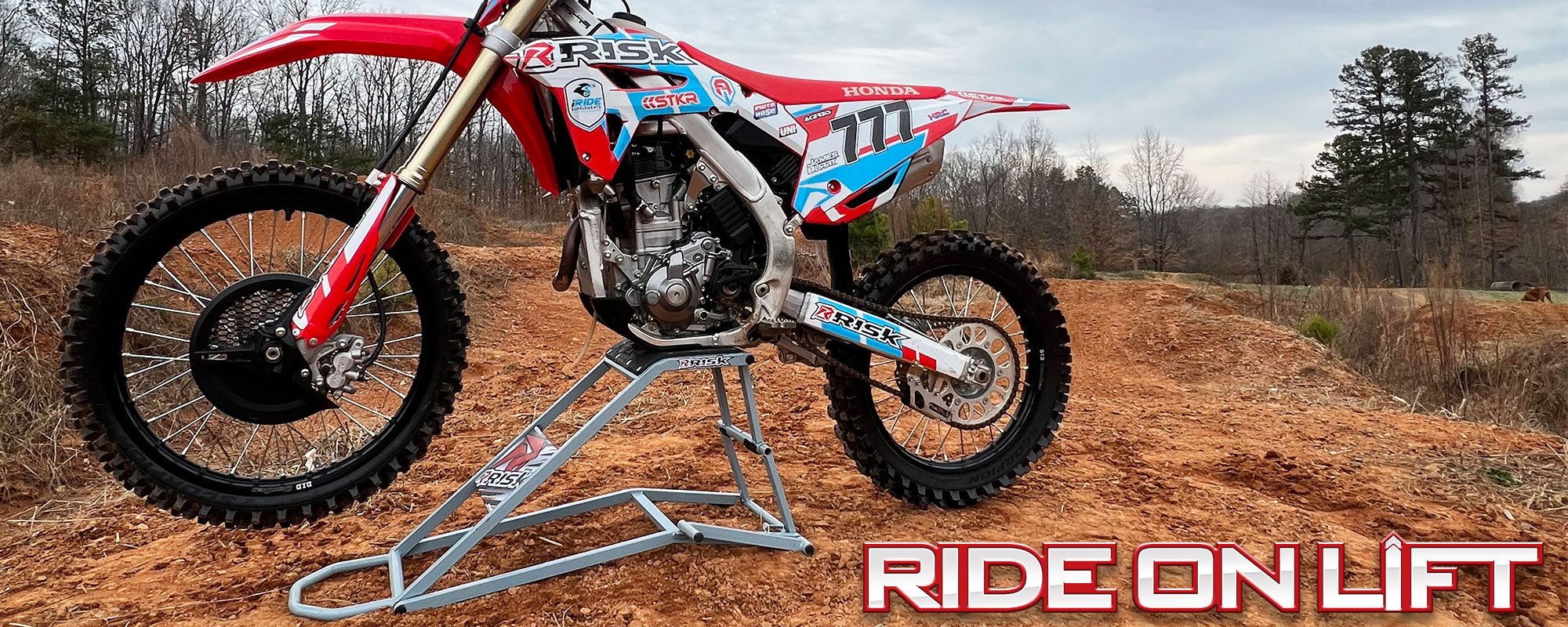 RR1 lifestyle poster featuring the lift/stand with a bike on it outside in a dirt/wooded area