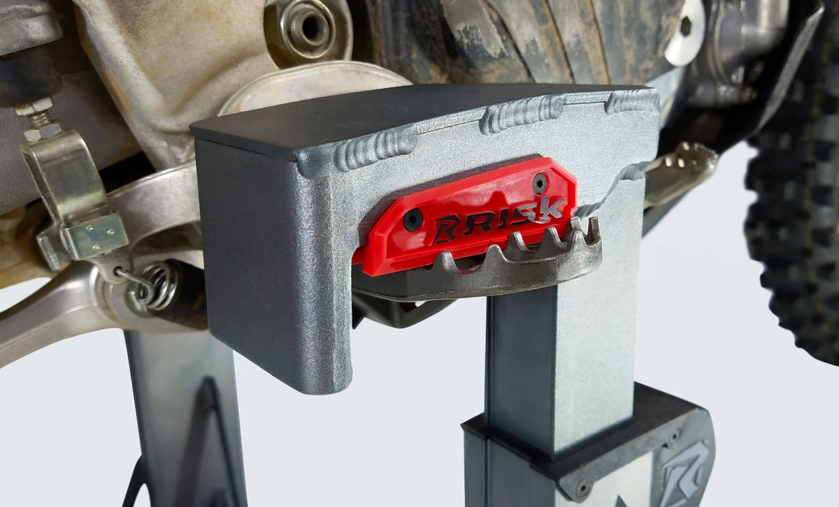 Close-up of the Lock-N-Load Pro jaw clamped over a dirt bike footpeg